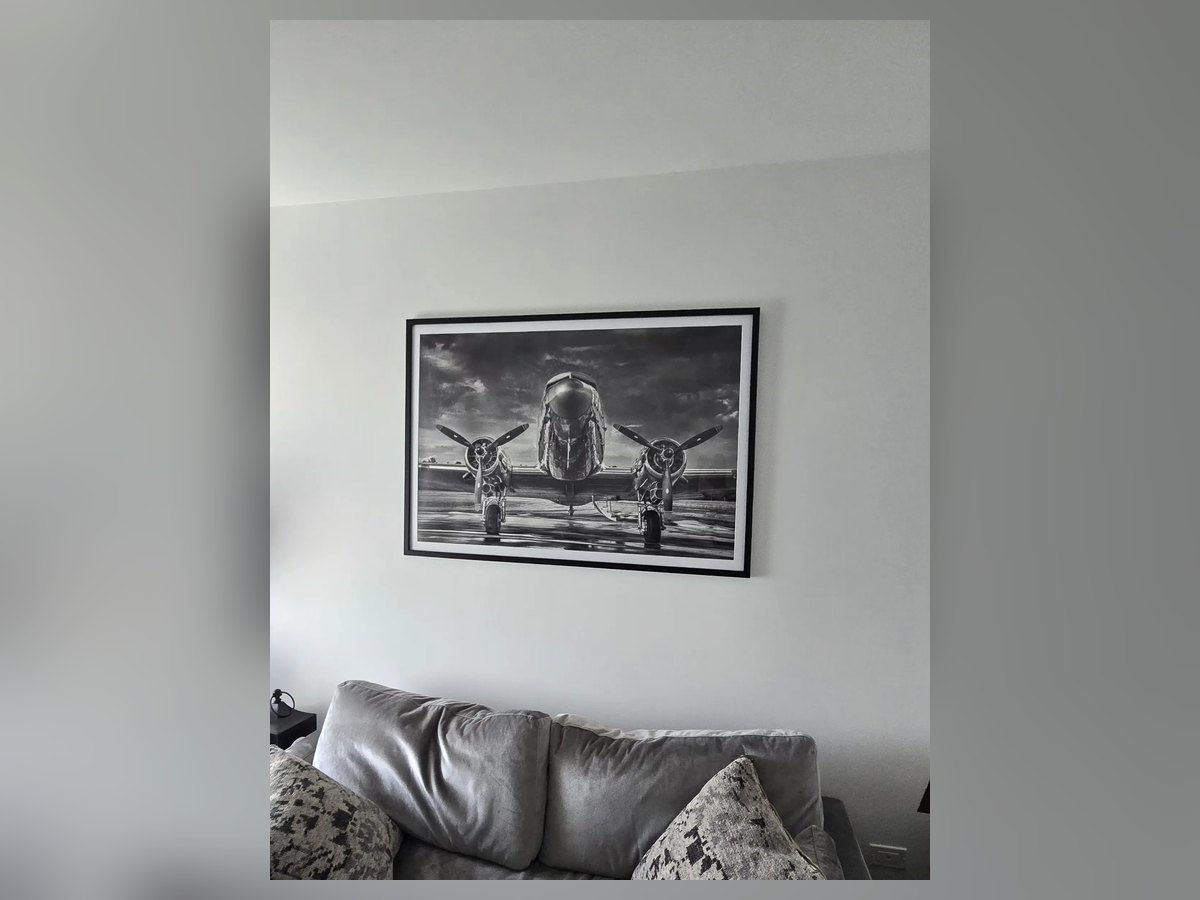 Large framed black and white print hung over a sofa