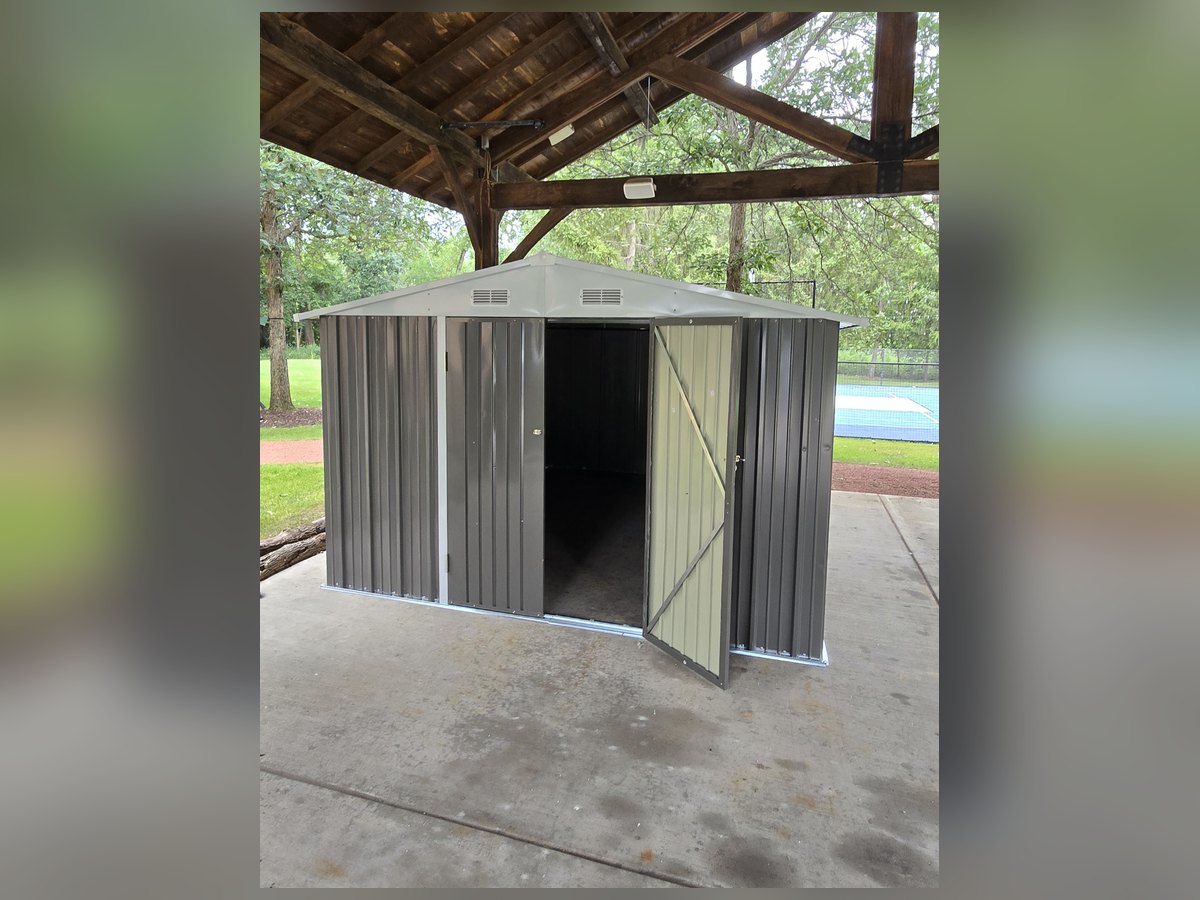 Metal storage shed assembled outdoors with doors open