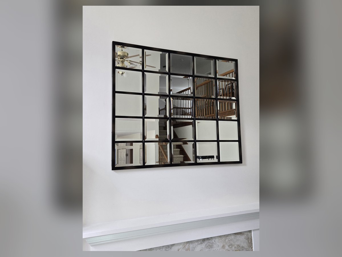 Large window-pane style mirror hung on a wall